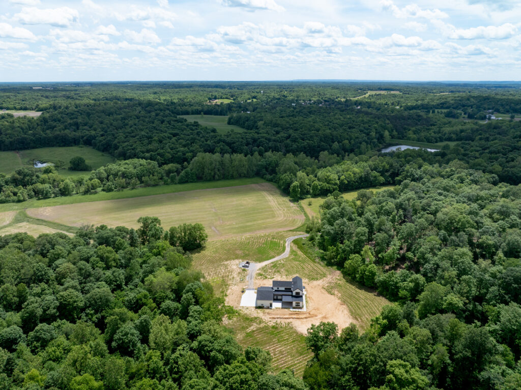 Contemporary Louisville luxury home surrounded by greenery, captured from above.