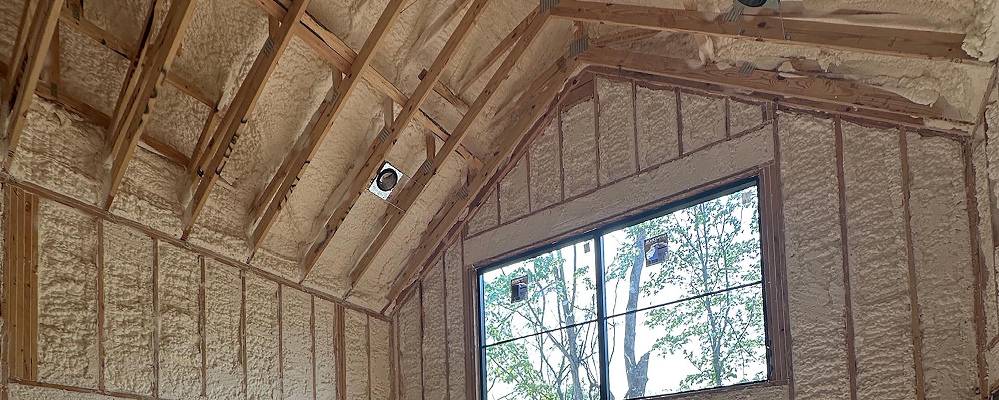 New custom home Louisville KY construction site with exposed beams and spray foam wall insulation.