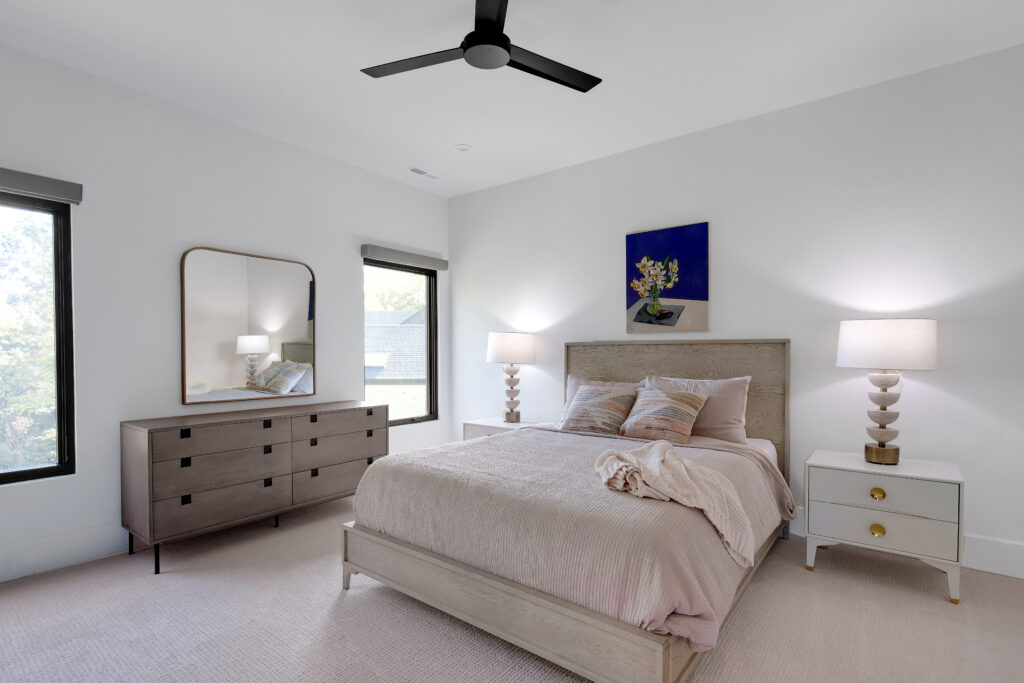 Louisville minimalist bedroom with light wood bed and modern lamps by top custom home builders, Eldridge Company.