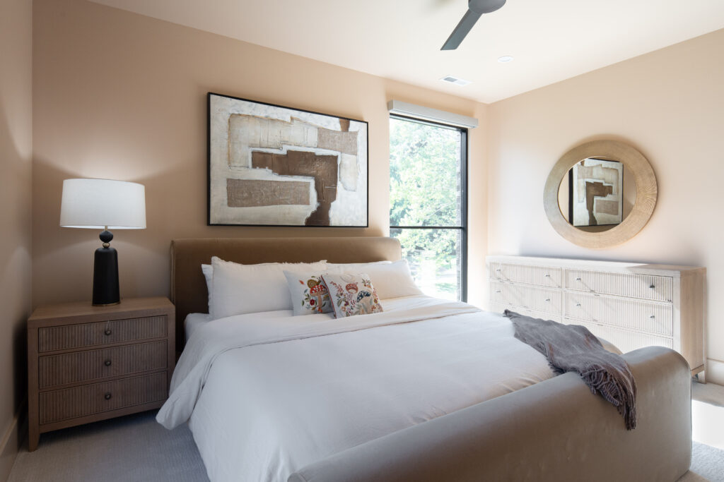 Louisville beige bedroom with large bed, abstract art, and serene design by top custom home builders Eldridge Company.