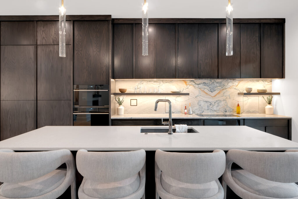 Louisville modern kitchen with dark wood cabinets, marble backsplash, and white island by top custom home builders Eldridge Company.
