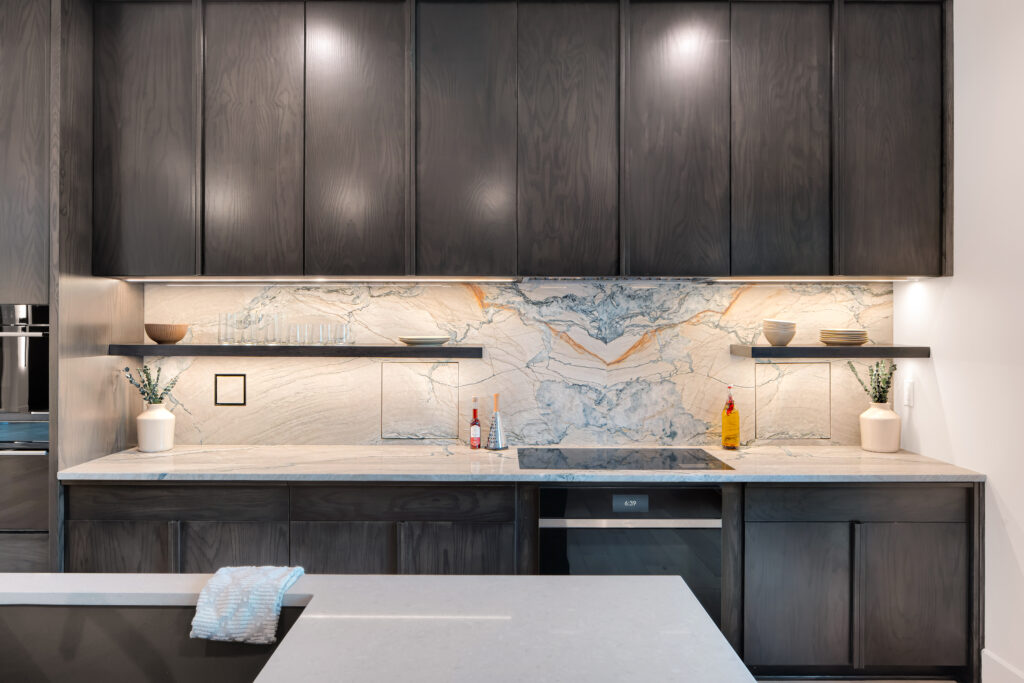 Prospect KY modern kitchen at Homearama 2025 with custom dark cabinetry, marble backsplash, open shelves, and stylish decorative accents.