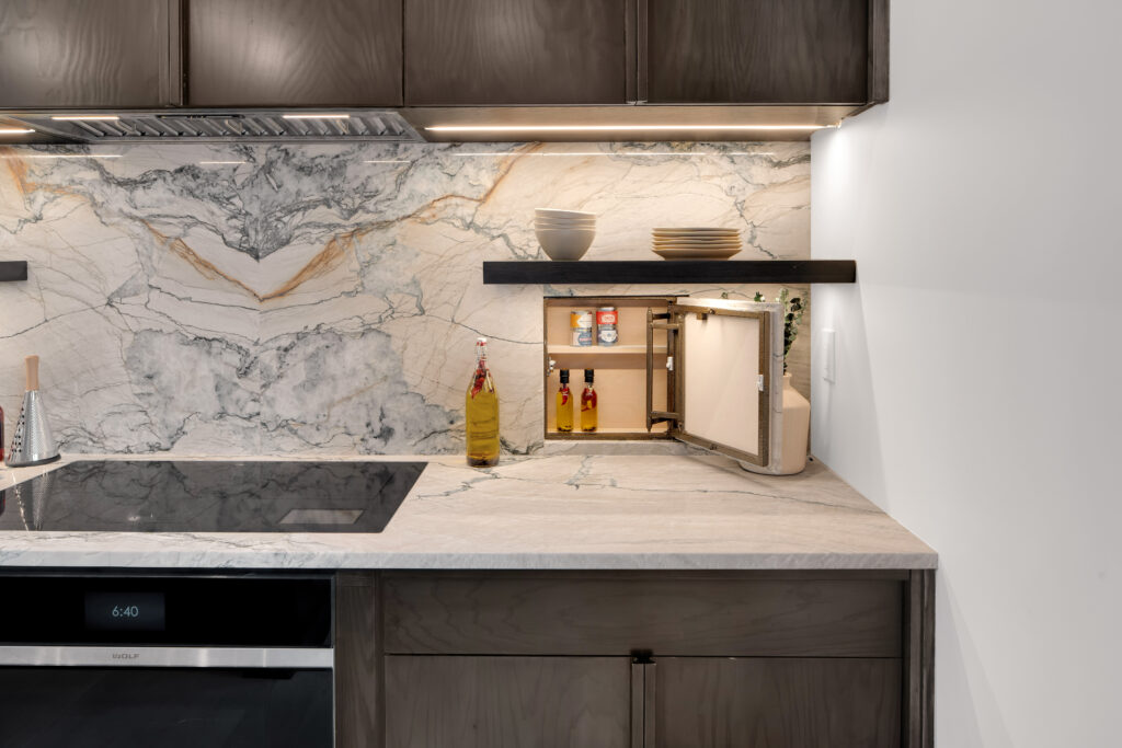 Louisville modern kitchen with dark wood cabinets, marble backsplash, and sleek appliances by top custom home builders.
