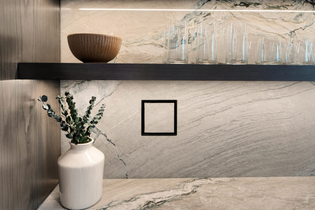Louisville modern kitchen with veiny marble countertop and sleek black shelf by top custom home builders.