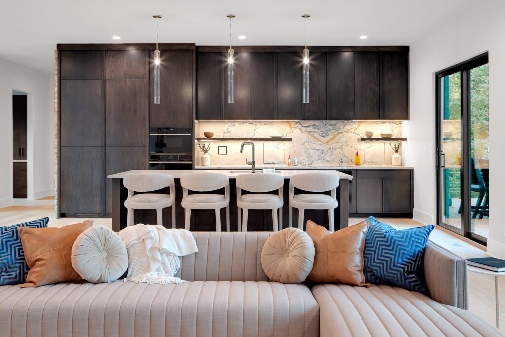 Modern Louisville kitchen with dark cabinets, marble backsplash, and island by top custom home builders.