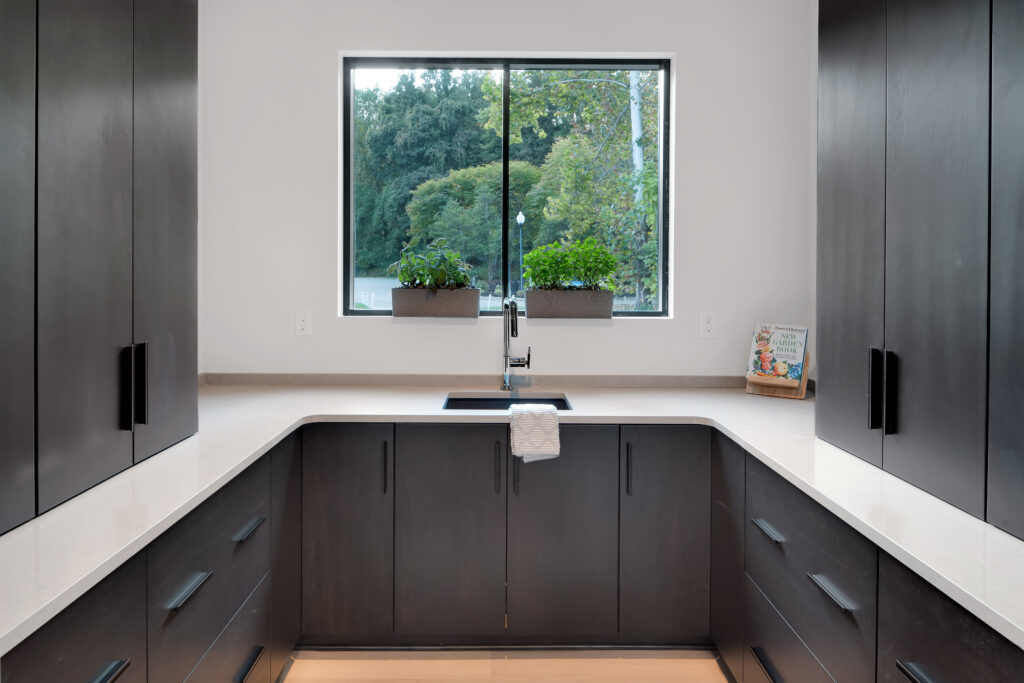 Modern Louisville kitchen with dark wood cabinets and white countertops by top custom home builders.
