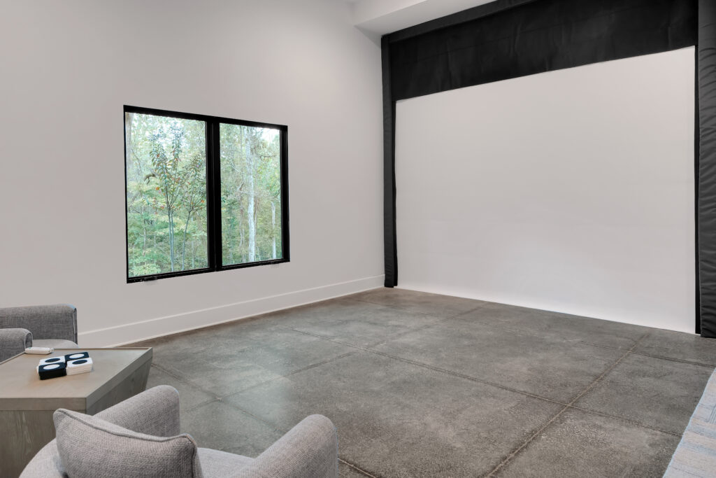 Louisville minimalist room with gray armchairs and table, serene greenery view by top modern home builders.