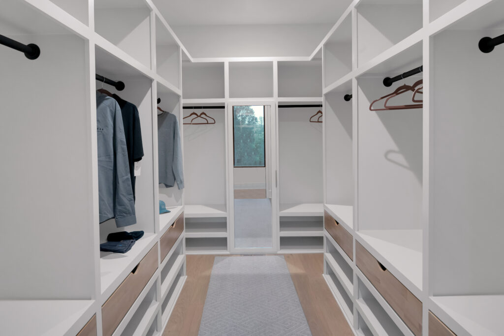 Louisville modern walk-in closet with white shelves and organized storage by top custom home builders.