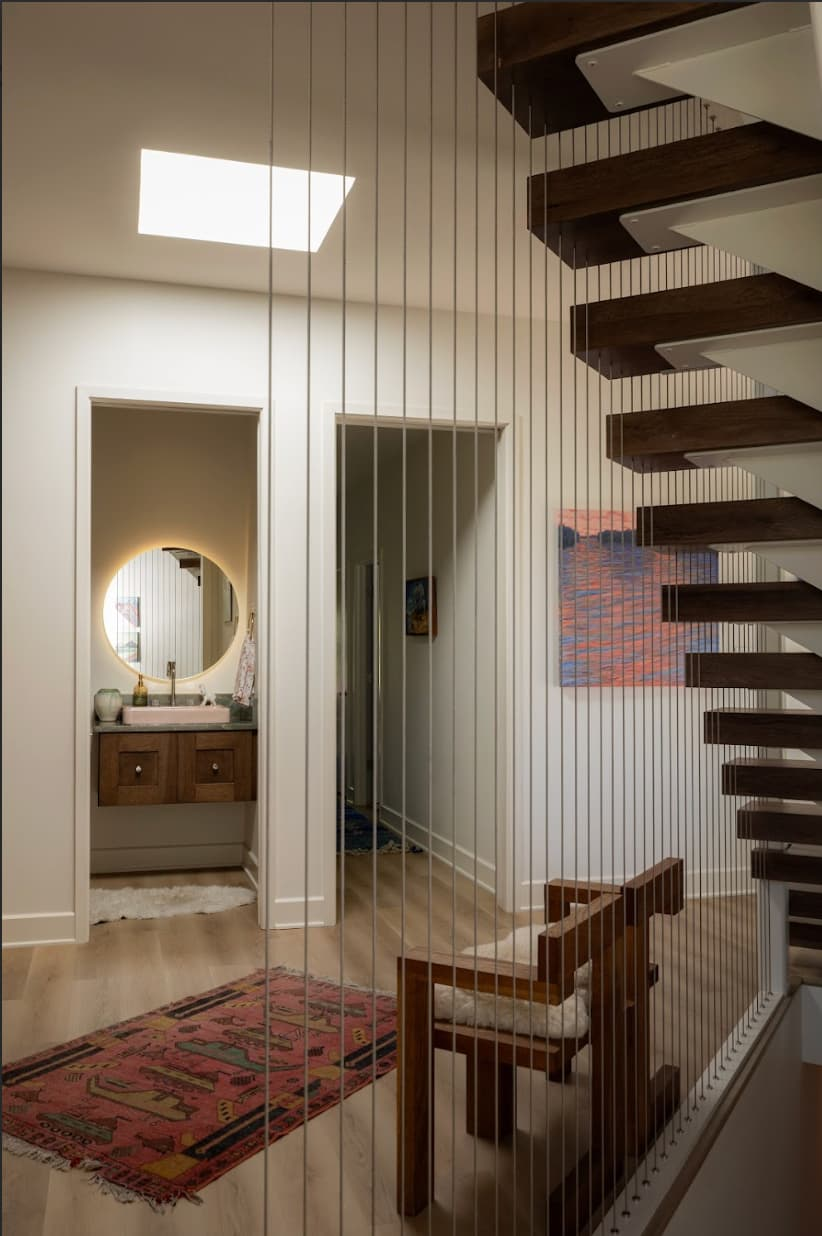 Floating staircase with cable detailing overlooking foyer in Louisville custom home.
